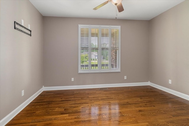 empty room featuring a ceiling fan, wood finished floors, and baseboards