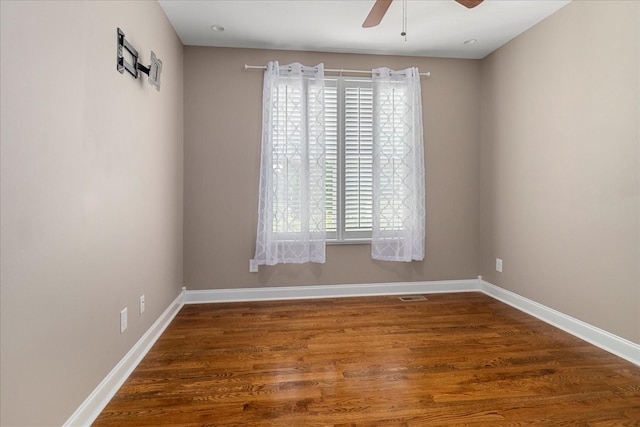 spare room with a ceiling fan, baseboards, and wood finished floors