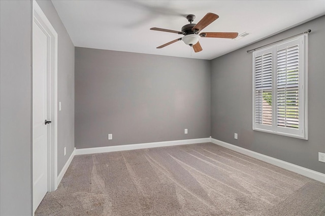 carpeted empty room featuring ceiling fan and baseboards
