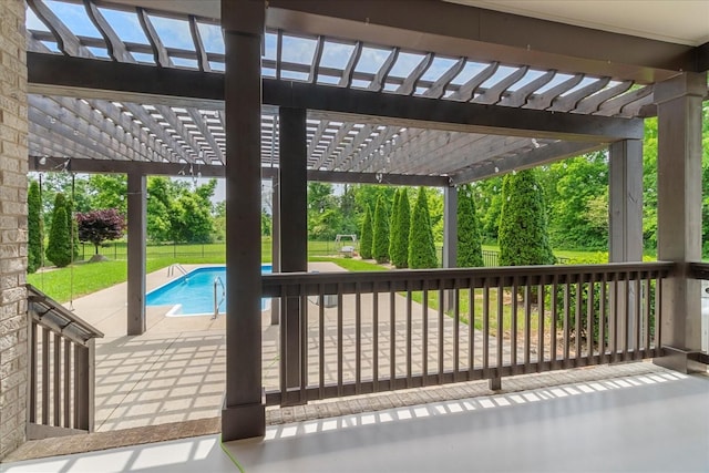 view of patio / terrace featuring a pergola, an outdoor pool, and view of scattered trees
