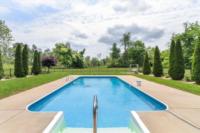 view of swimming pool with view of scattered trees