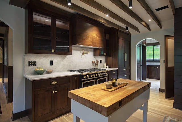 5564 Wilkins Branch Rd, Franklin, TN 37064 - kitchen featuring arched walkways, double oven range, wooden counters, decorative backsplash, and light wood-style flooring