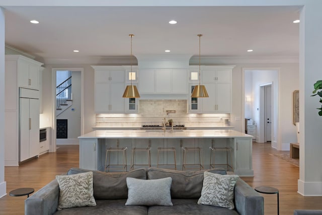 1461 Witherspoon Dr, Brentwood, TN 37027 - kitchen with white cabinetry, tasteful backsplash, a large island with sink, crown molding, and light countertops
