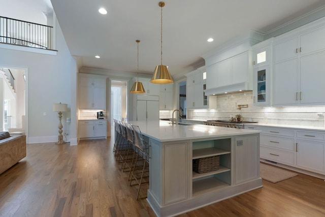 1461 Witherspoon Dr, Brentwood, TN 37027 - kitchen with a sink, decorative backsplash, light countertops, a large island with sink, and glass insert cabinets
