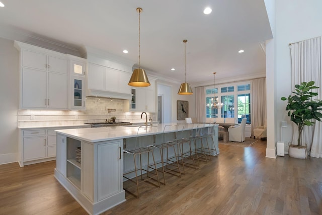 1461 Witherspoon Dr, Brentwood, TN 37027 - kitchen with stainless steel gas stovetop, backsplash, white cabinets, light countertops, and a breakfast bar area