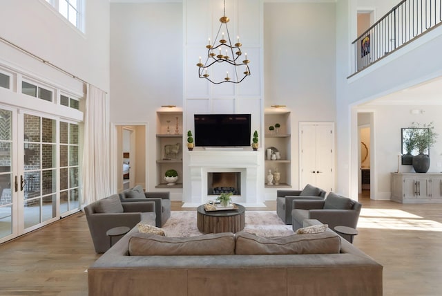 1461 Witherspoon Dr, Brentwood, TN 37027 - living area with a high ceiling, a chandelier, wood finished floors, a fireplace with flush hearth, and built in features