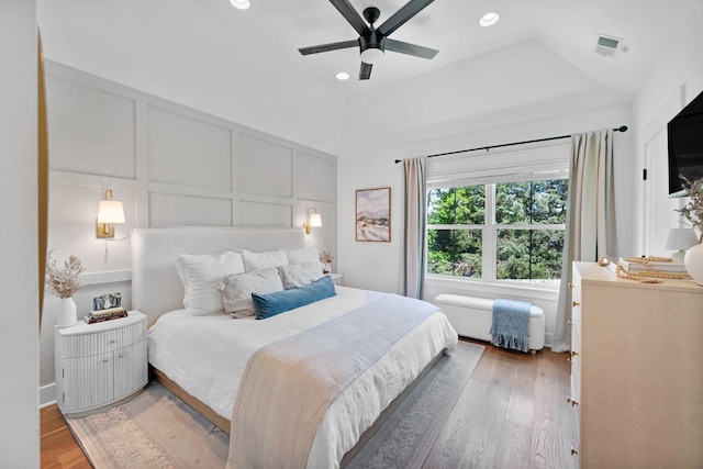 bedroom featuring a decorative wall, light wood-type flooring, recessed lighting, and ceiling fan