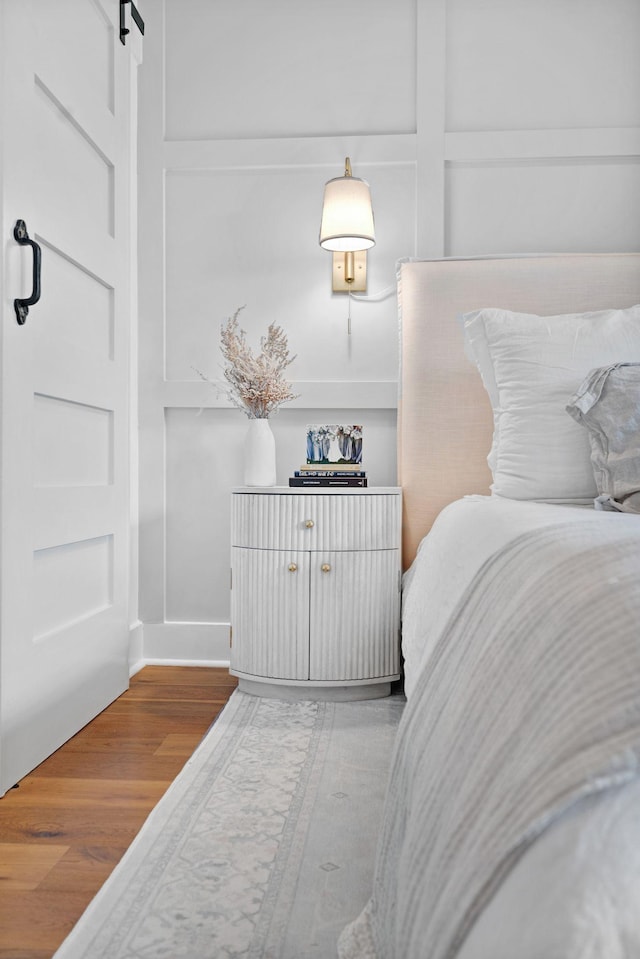 bedroom featuring wood finished floors and a barn door