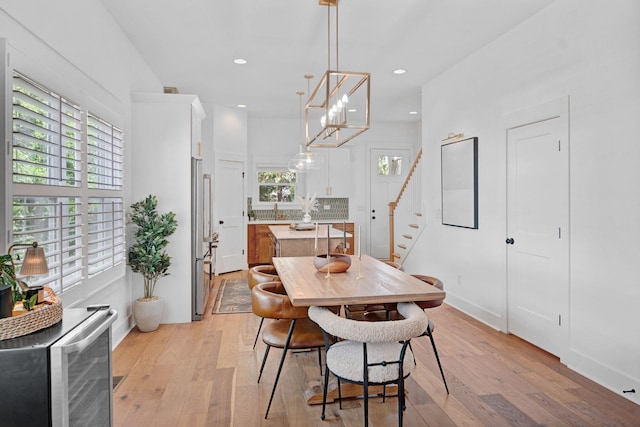dining area featuring stairway, healthy amount of natural light, light wood-type flooring, and recessed lighting