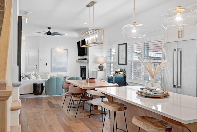 kitchen featuring high end fridge, light wood-type flooring, a ceiling fan, open floor plan, and light countertops