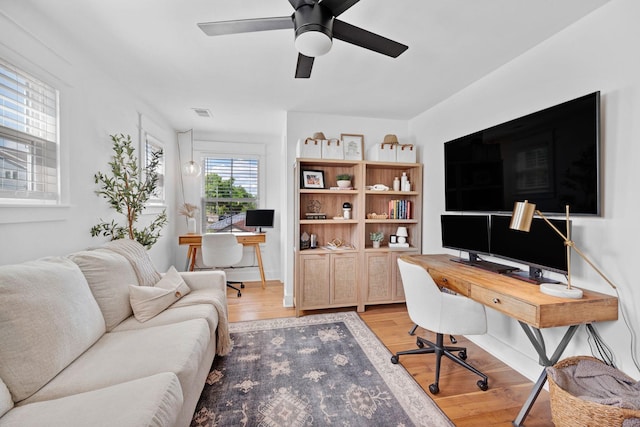 home office with light wood-style floors and ceiling fan