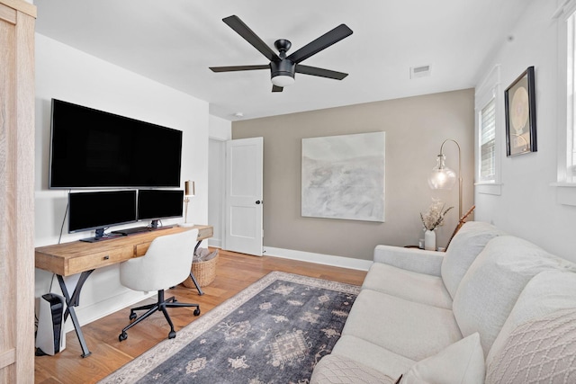 home office with wood finished floors, ceiling fan, and baseboards