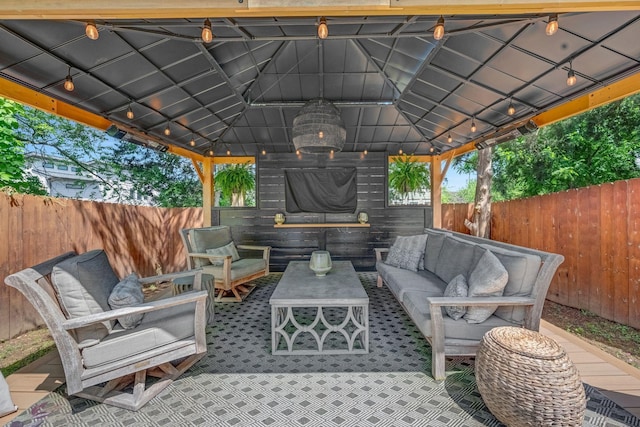 view of patio featuring a gazebo, an outdoor living space, and fence
