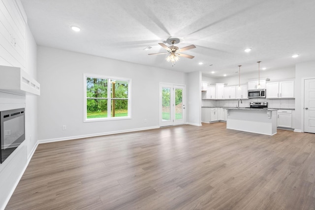 209 Wesson Dr, Clarksville, TN 37043 - unfurnished living room with ceiling fan, a sink, light wood-type flooring, recessed lighting, and baseboards