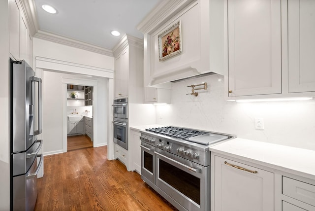 3031 Trice Pl, Lebanon, TN 37087 - kitchen with stainless steel appliances, ornamental molding, white cabinetry, backsplash, and wood finished floors
