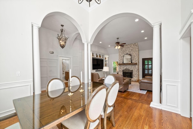 3031 Trice Pl, Lebanon, TN 37087 - dining space featuring decorative columns, a ceiling fan, arched walkways, light wood finished floors, and a fireplace