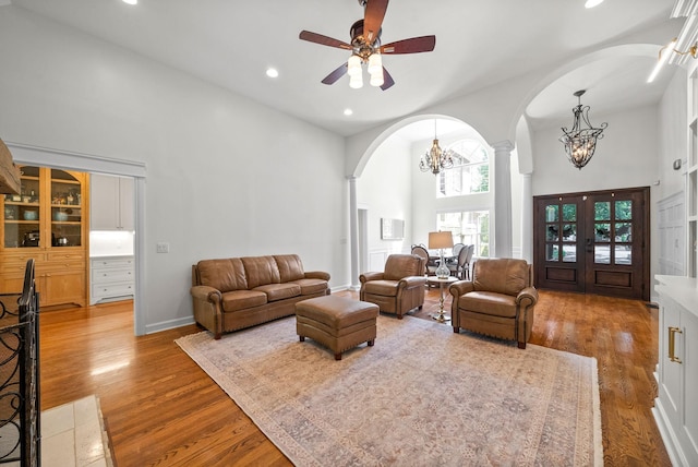 3031 Trice Pl, Lebanon, TN 37087 - living area featuring arched walkways, a chandelier, a towering ceiling, wood finished floors, and a ceiling fan