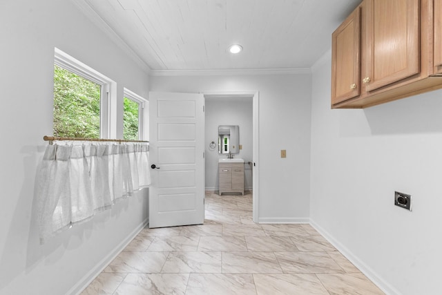 laundry room with cabinet space, ornamental molding, electric dryer hookup, light marble finish floors, and baseboards