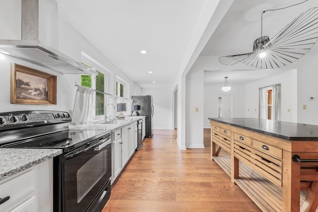 kitchen featuring black appliances, a sink, wall chimney exhaust hood, white cabinetry, and recessed lighting