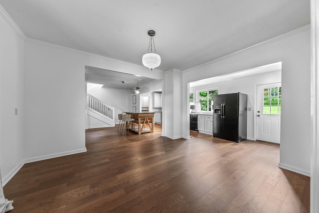 unfurnished living room featuring stairway, dark wood-style floors, crown molding, and baseboards