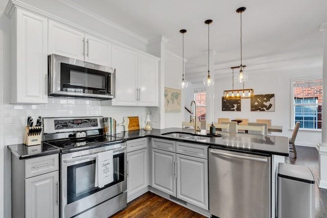 1206 Forest Lake Ct, Franklin, TN 37064 - kitchen with appliances with stainless steel finishes, a sink, a peninsula, dark countertops, and healthy amount of natural light