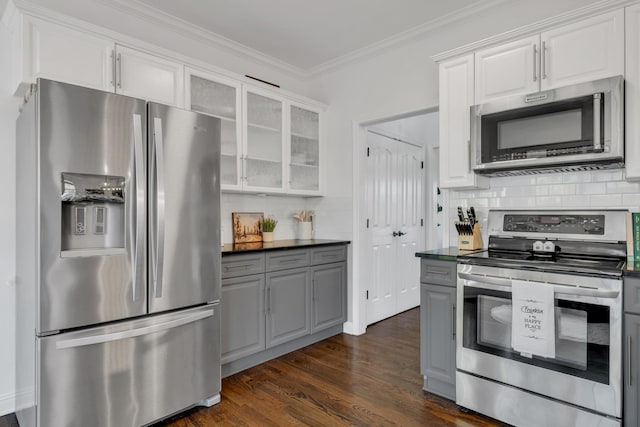 1206 Forest Lake Ct, Franklin, TN 37064 - kitchen with appliances with stainless steel finishes, decorative backsplash, dark countertops, glass insert cabinets, and ornamental molding