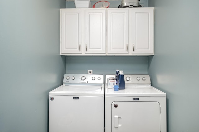 washroom featuring independent washer and dryer and cabinet space