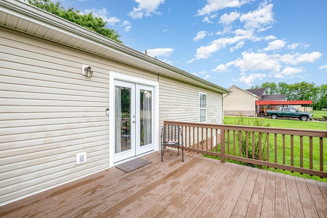 wooden terrace featuring french doors and a lawn
