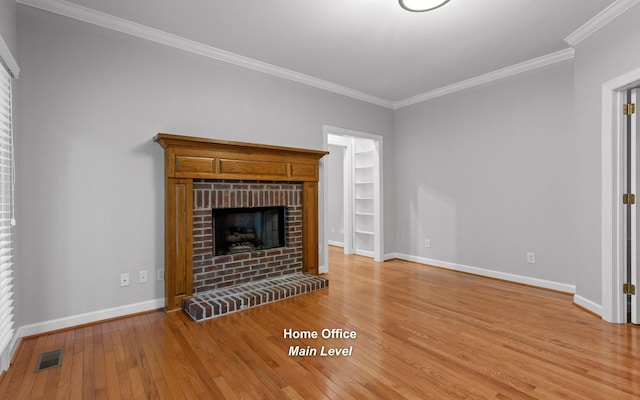 unfurnished living room with light wood-style flooring, ornamental molding, baseboards, and a fireplace