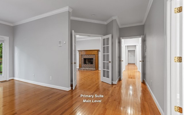 corridor featuring light wood-style flooring, crown molding, and baseboards