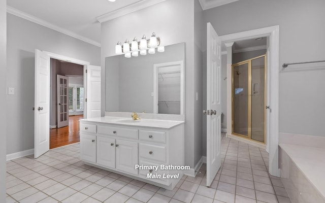 bathroom featuring ornamental molding, tile patterned floors, a shower stall, vanity, and a walk in closet