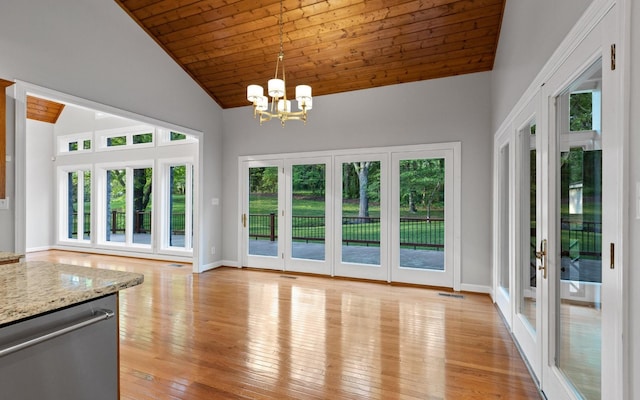 unfurnished dining area featuring french doors, plenty of natural light, a chandelier, high vaulted ceiling, and wood ceiling