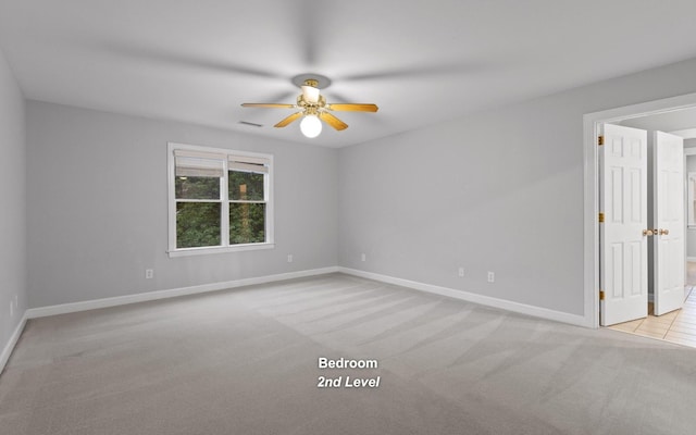 unfurnished room featuring carpet flooring, ceiling fan, and baseboards
