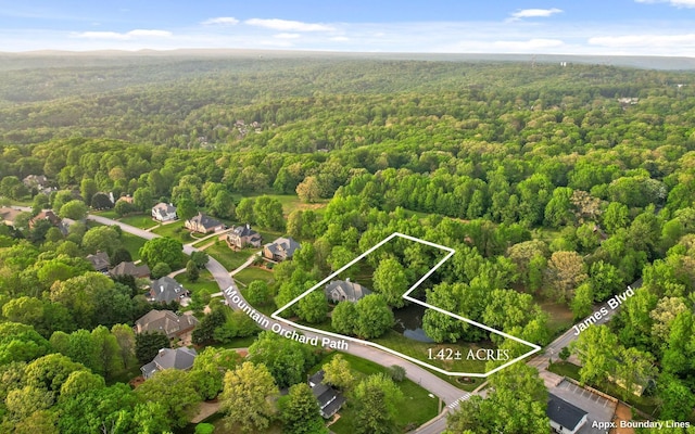 aerial view of property and surrounding area with a heavily wooded area and property boundaries highlighted