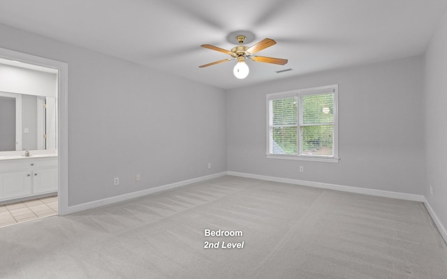 unfurnished bedroom featuring light carpet, baseboards, a sink, connected bathroom, and ceiling fan