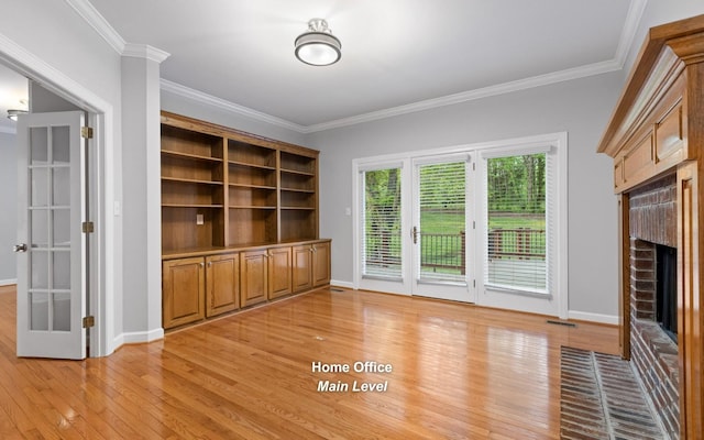 unfurnished living room featuring a brick fireplace, light wood-style floors, crown molding, and baseboards