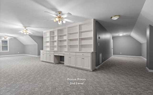 additional living space with light colored carpet, a ceiling fan, lofted ceiling, and baseboards