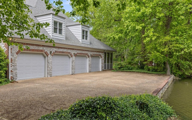 garage featuring a water view and driveway