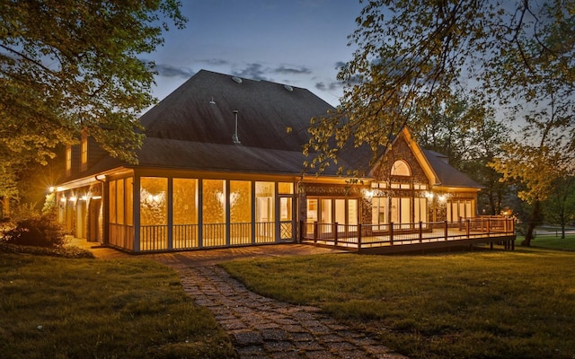 back of property with a yard and a wooden deck