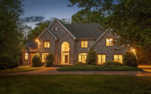 view of front facade with a front yard and stone siding