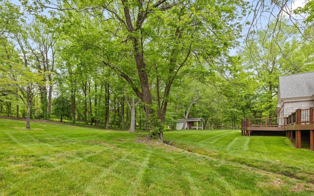 view of green lawn featuring a wooden deck