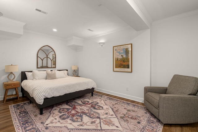 bedroom featuring wood finished floors, ornamental molding, baseboards, and recessed lighting