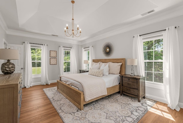 bedroom with a chandelier, baseboards, light wood finished floors, and crown molding