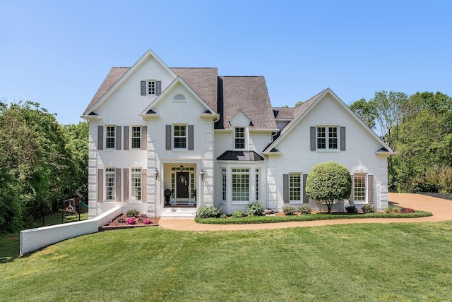 view of front of house with a front lawn and roof with shingles