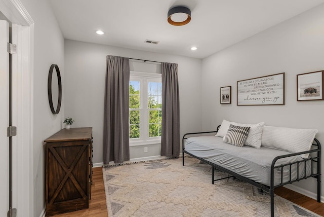 bedroom with baseboards, wood finished floors, and recessed lighting