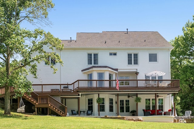 back of property featuring ceiling fan, stairway, a deck, and a yard