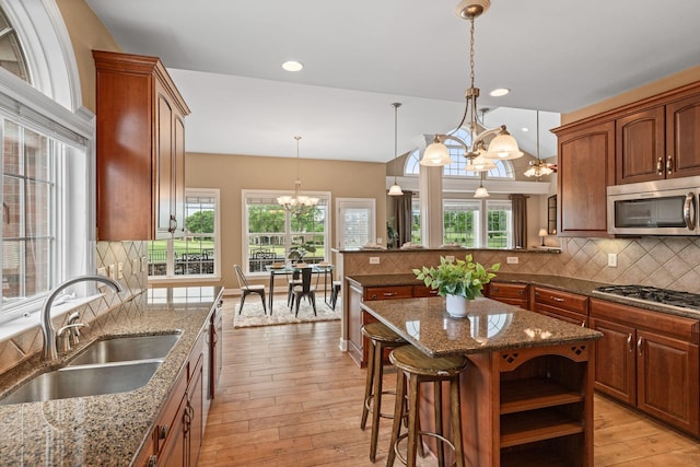 1115 Rossifer Ct, Gallatin, TN 37066 - kitchen with stainless steel appliances, a chandelier, a sink, light wood finished floors, and tasteful backsplash