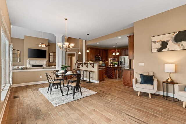 1115 Rossifer Ct, Gallatin, TN 37066 - dining room featuring a fireplace, a chandelier, a ceiling fan, light wood-type flooring, and recessed lighting