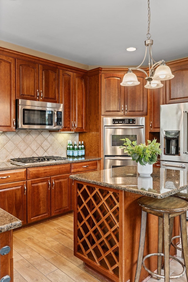 1115 Rossifer Ct, Gallatin, TN 37066 - kitchen with stainless steel appliances, light wood-style floors, dark stone counters, decorative backsplash, and recessed lighting