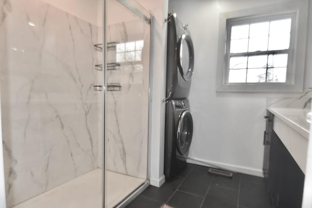 full bathroom featuring stacked washer / drying machine, a marble finish shower, and vanity
